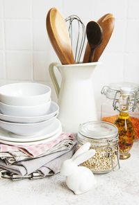Kitchen utensils, tools and dishware on on the background white tile wall. 