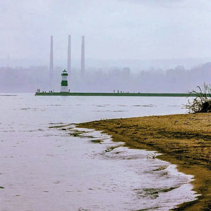 water, tranquility, sea, tranquil scene, built structure, sky, architecture, scenics, nature, lighthouse, beauty in nature, river, lake, waterfront, guidance, fog, foggy, building exterior, outdoors, no people