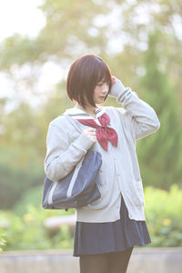 Young woman in school uniform at park