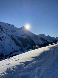 Scenic view of snow covered mountains against clear sky