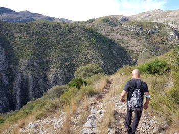 Rear view of man walking on mountain