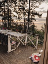 Empty chairs and table against trees