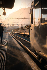 Train at railroad station against sky during sunset