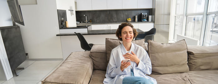 Young woman using mobile phone at home