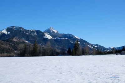 Scenic view of snowcapped mountains against clear blue sky