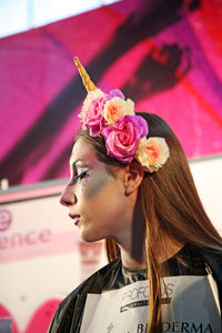 Close-up of woman with pink flower