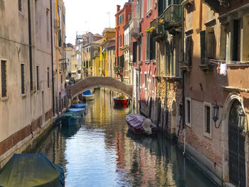 Boats in canal amidst buildings in city