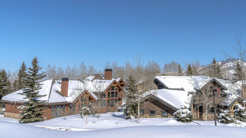 Snow covered houses and buildings against sky