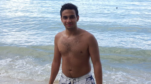 Portrait of young man standing at beach