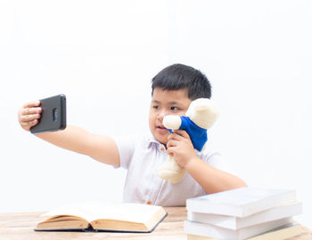 Full length of man reading book against white background