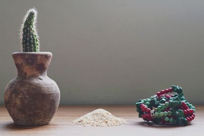 Close-up of cactus on table with crystal bracelet