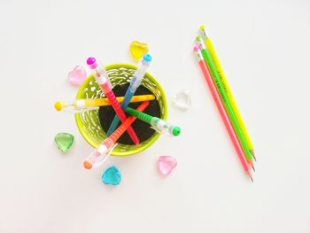 High angle view of colored pencils against white background