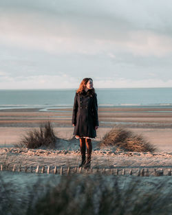 Full length of man standing on beach against sky