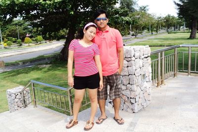 Full length of couple standing by railing