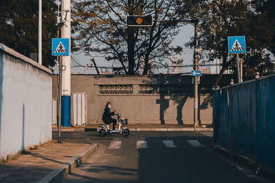 Portrait of woman wearing mask riding electric motor scooter on road