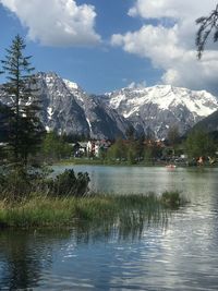 Scenic view of lake by snowcapped mountains against sky