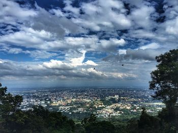 Aerial view of sea and cityscape against sky