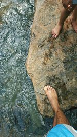 Low section of man standing on rock in river