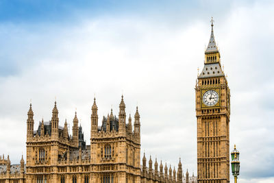 Big ben and palace of westminster against cloudy sky in city