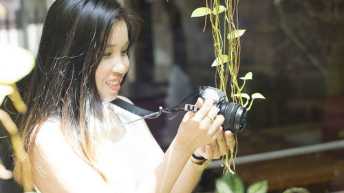 Portrait of woman holding plant