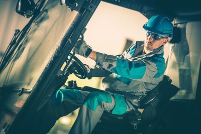 Mid adult man driving truck in factory