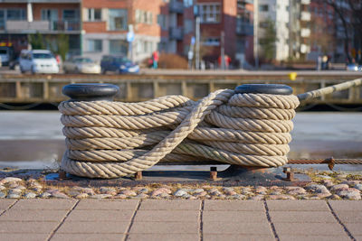 Close-up of rope tied to wooden post at harbor