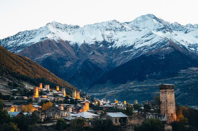 Houses on snowcapped mountain against sky