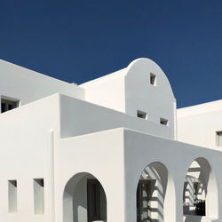 Low angle view of white building against clear blue sky