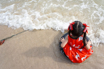 High angle view of man sitting on shore