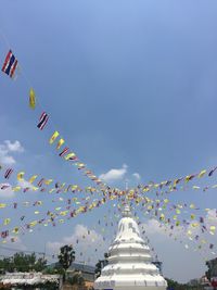 Low angle view of flags hanging in city against sky