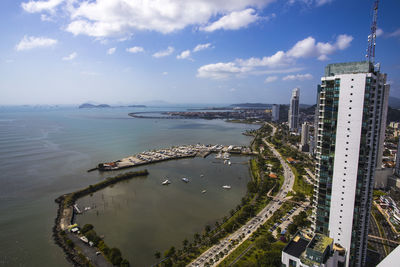 High angle view of city by sea against sky