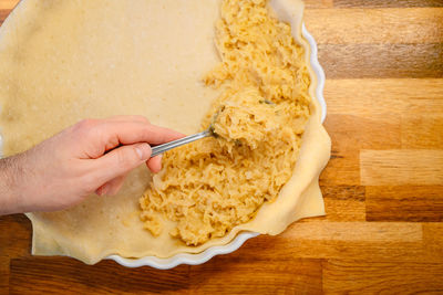 Person preparing apple pie on kitchen counter