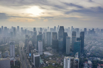 High angle view of modern buildings in city against sky during sunset