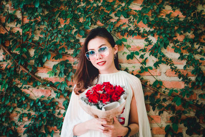 Portrait of young woman holding food outdoors