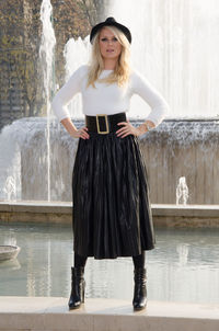 Portrait of smiling woman standing against waterfall