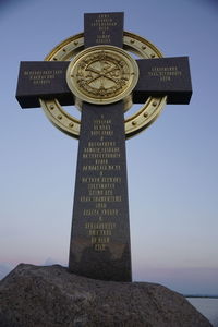 Low angle view of cross sign against sky