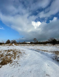 Scenic view of snow covered land against sky