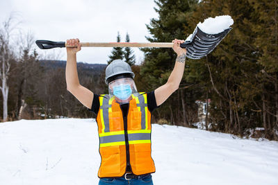 Full length of man holding umbrella in snow