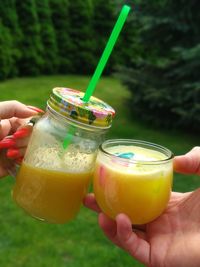 Close-up of hand holding glass of juice