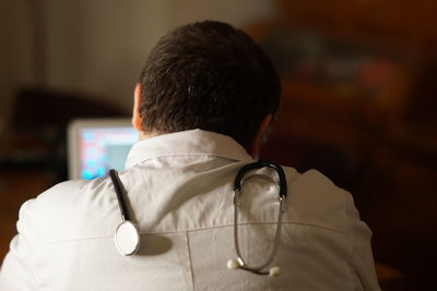 Rear view of mature doctor working in hospital