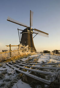 Traditional windmill on field against clear sky