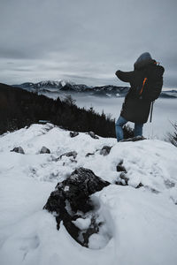 Man standing on snowy land against sky