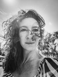 Portrait of smiling woman with tousled hair outdoors