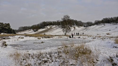 Scenic view of snow covered field against sky