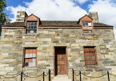 Low angle view of old building against cloudy sky