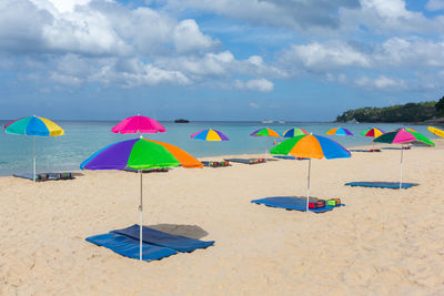 Multi colored umbrella on beach against sky