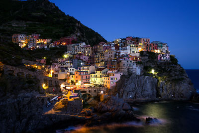 Townscape by sea against sky during sunset