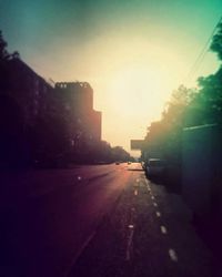 Cars on road in city against clear sky