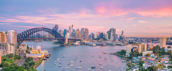 Bridge over river with buildings in background at sunset