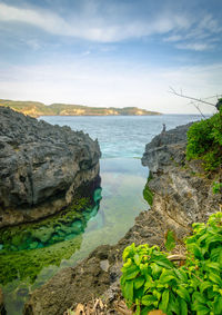 Rock formations by sea against sky